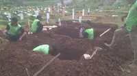 Petugas tengah menggali makam untuk tiga korban pembunuhan sadis Pulomas. (Liputan6.com/M. Radityo P)