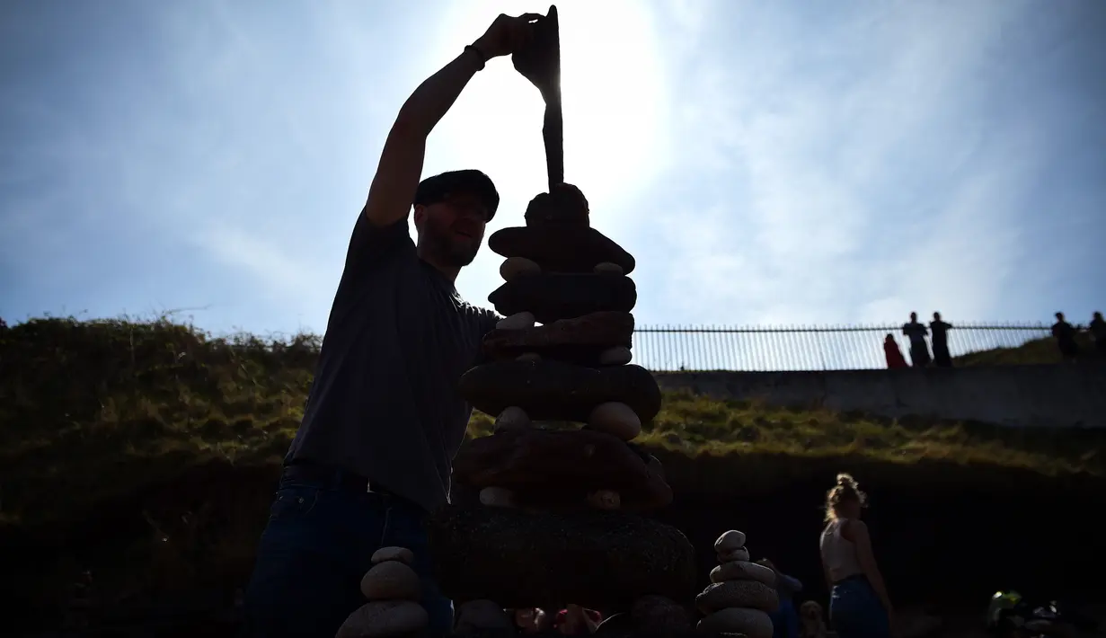 Laurence Winram dari Edinburgh berkompetisi dalam Kejuaraan Menumpuk Batu Eropa 2019 di Dunbar, Skotlandia, Minggu (21/4). Pemenang dalam kejuaraan tersebut akan terbang ke llano Earth Art Festival dan mengikuti World Stone Balancing Competition 2020. (Andy Buchanan / AFP)