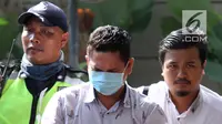 Kepala Kantor Imigrasi Kelas I Mataram Kurniadie (tengah) tiba di Gedung KPK, Jakarta, Selasa (28/5/2019). Kurniadie terjaring operasi tangkap tangan (OTT) KPK bersama tujuh orang lainnya. (Liputan6.com/HO/Joni)