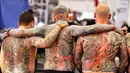 Tiga pria dari Belanda menunjukkan tato di punggung mereka pada hari pertama Konvensi Tattoo Frankfurt di Frankfurt, Jerman (21/4). Ratusan seniman tato ramaikan ajang pertemuan para pecinta seni menggambar tubuh ini. (AP Photo / Michael Probst)