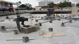 Pekerja melakukan pengerjaan revitalisasi Taman Lapangan Banteng, Jakarta Pusat, Rabu (7/3). Revitalisasi Taman Lapangan Banteng ditargetkan rampung pada akhir Maret 2018. (Liputan6.com/Arya Manggala)