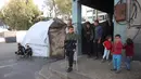 Rateb Mahmoud Qaliq terluka akibat serangan udara Israel di Khan Yunis, di Jalur Gaza selatan pada 28 Juni 2025. Tampak dalam foto, Rateb Mahmoud Qaliq (tengah) menggunakan kruk di halaman sekolah UNRWA yang telah menjadi tempat penampungan bagi pengungsi Palestina di Deir al-Balah, di Jalur Gaza tengah, pada 3 Desember 2025. (Bashar Taleb/AFP)