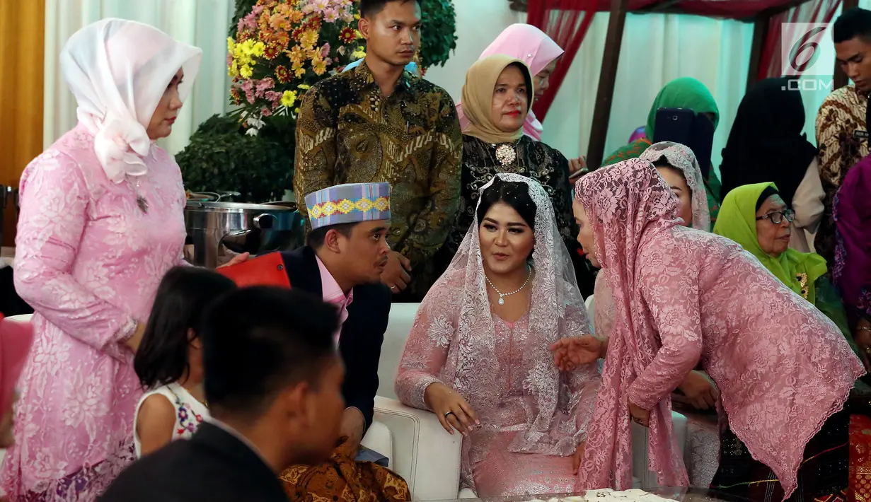 Kahiyang Ayu berbincang dengan Bobby Nasution saat prosesi pemberian marga dengan Manortor atau menari Tortor di rumah Pamannya Bobby Nasution di Medan, Selasa (21/11). (Liputan6.com/JohanTallo)