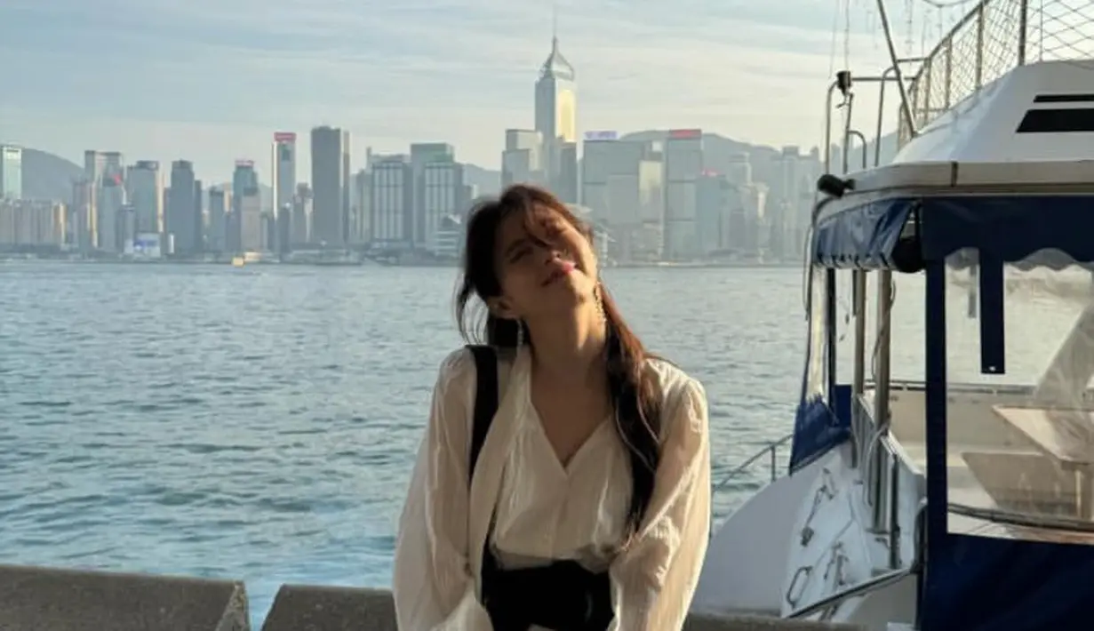 Han So Hee tampil mengenakan mini dress putih lengan panjang saat berada di pinggir pantai. Dipadukan belt hitam senada dengan sling bagnya. [xeesoxee]