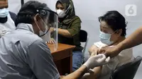 Vaksinator usai menyuntikan vaksin Covid-19 kepada warga lansia di halaman Kantor Kecamatan Penjaringan, Jakarta, Kamis (19/8/2021). Vaksinasi malam ini digelar untuk menjangkau warga yang tidak bisa vaksinasi pada siang hari karena bekerja dan alasan lainnya. (Liputan6.com/Helmi Fithriansyah)