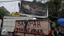 Warga dan petugas Satpol PP menurunkan papan reklame rokok, Jakarta, Rabu (18/11). Gubernur DKI Jakarta menerbitkan Peraturan Gubernur Nomor 1 Tahun 2015 tentang Larangan Penyelenggaraan Reklame Rokok pada Media Luar Ruang. (Liputan6.com/Gempur M Surya)