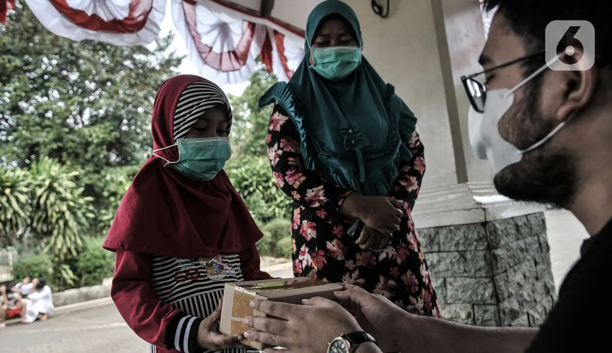 Seorang anak menerima donasi ponsel yang diberikan oleh Komunitas #WartawanLintasMedia saat acara #PonselPintarUntukPelajar di Jakarta, Minggu (9/8/2020). (merdeka.com/Iqbal S. Nugroho)