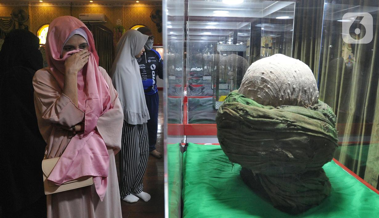 Pengunjung menangis melihat serban Nabi Muhammad SAW saat Pameran Artefak Rasulullah dan Sahabat Nabi di Padepokan Welas Asih, Parung, Kabupaten Bogor, Jawa Barat, Minggu  (26/7/2020). Sebanyak 20 benda peninggalan Nabi Muhammad dan sahabatnya dipamerkan dalam acara ini. (merdeka.com/Arie Basuki)