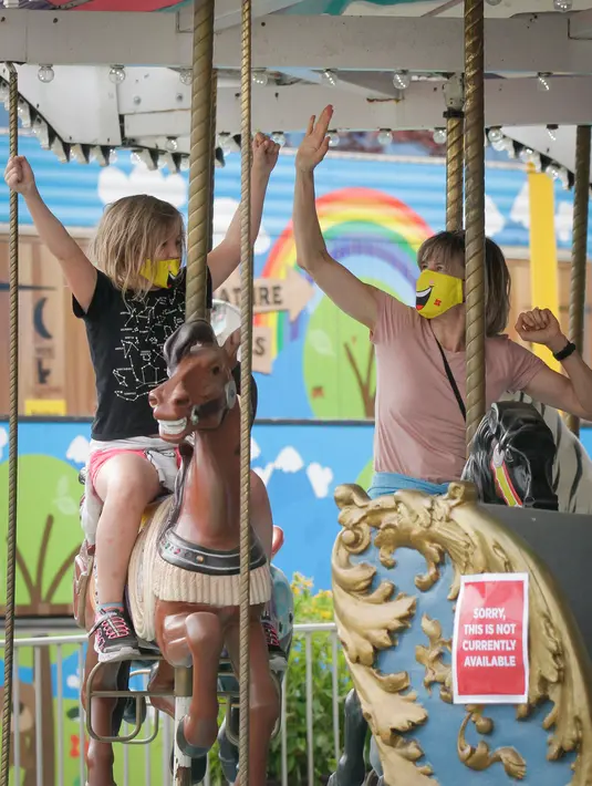 Para pengunjung yang mengenakan masker bersenang-senang menaiki wahana di Playland Amusement Park, di Vancouver, British Columbia, Kanada, pada 10 Juli 2020. Playland Amusement Park dibuka kembali untuk umum pada Jumat (10/7), dengan langkah-langkah protokol kesehatan. (Xihua/Liang Sen)