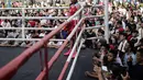 Warga menyaksikan pertandingan tinju amatir yang berlangsung saat Car Free Day di kawasan Bundaran HI, Jakarta, Minggu (29/4). Pertandingan tinju car free day tersebut untuk mendukung penyelenggaraan Asian Games 2018. (Liputan6.com/Faizal Fanani)