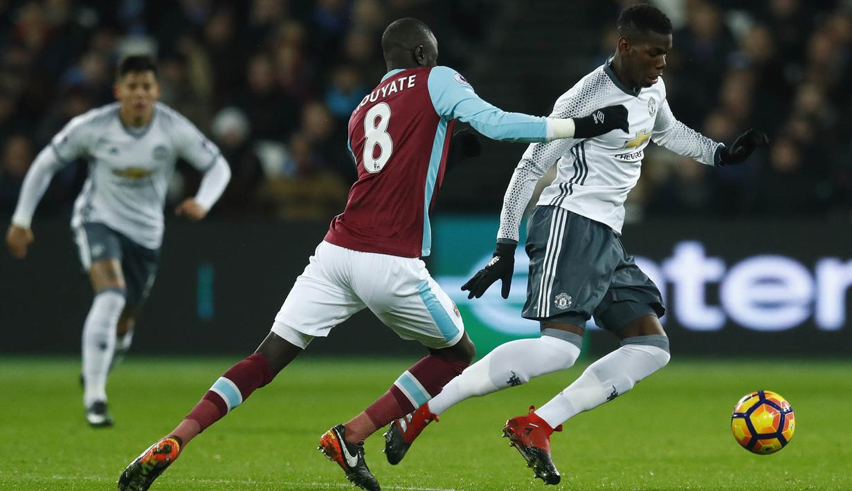 Gelandang Mnachester United, Paul Pogba, berusaha melewati gelandang West Ham, Cheikhou Kouyate. Pada laga ini total MU melakukan 13 kali percobaan mencetak gol, sementara tuan rumah hanya delapan kali mendapatkan kesempatan. (Reuters/Eddie Keogh)