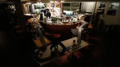 Pekerja menyiapkan minuman setelah mereka memasang lintasan mobil balap mainan di sebuah bar di Praha, Republik Ceko, 15 Oktober 2020. Area bar menjadi lintasan mobil mainan yang bisa dimanfaatkan para karyawan untuk mengusir kebosanan saat menunggu pesanan. (AP Photo/Petr David Josek)