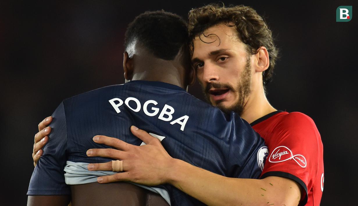 Striker Southampton, Manolo Gabbiadini, menghibur gelandang Manchester United, Paul Pogba, usai laga Premier League di Stadion St Mary, Manchester, Sabtu (1/12). Kedua klub bermain imbang 2-2. (AFP/Glyn Kirk)