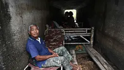 Mereka berlindung di beberapa lokasi yang dianggap aman, seperti pagoda, sekolah, dan tempat lainnya. Tampak dalam foto, petani Thailand, Boonkerd Yudeerum, duduk di dalam bunker bersama keluarganya di provinsi Surin pada Rabu 10 Desember 2025, selama bentrokan di sepanjang perbatasan Thailand-Kamboja. (Lillian SUWANRUMPHA/AFP)