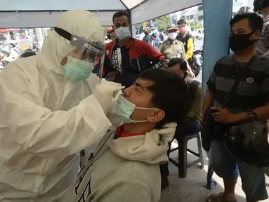 Petugas medis mendata pengendara yang terjaring razia masker di Jalan Panjang, Kedoya, Jakarta Barat, Senin (2812/2020). Pengendara yang tidak mengenakan masker langsung menjalani rapid test antigen gratis untuk mencegah penularan COVID-19. (merdeka.com/Dwi Narwoko)