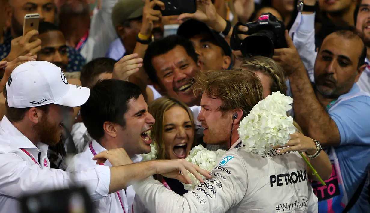 Nico Rosberg disambut anggota timnya setelah menjadi juara F1 GP Abu Dhabi yang berlangsung di Sirkuit Yas Marina, Abu Dhabi, UEA, Minggu (29/11/2015). (AFP/Marwan Naamani)