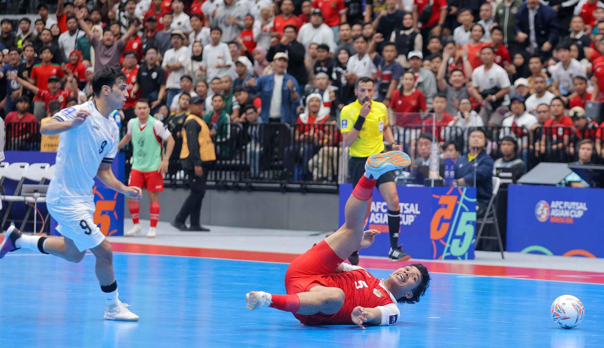 Pertandingan kian panas. Permainan cepat dan agresif yang dilancarkan kedua kubu mengakibatkan sejumlah pelanggaran terjadi. Tampak dalam foto, pemain Timnas Futsal Indonesia, Israr Megantara (kanan) terjatuh saat bertanding melawan Irak pada laga penyisihan Grup A Piala Asia Futsal 2026 di Indonesia Arena, Kompleks Gelora Bung Karno, Senayan, Jakarta, Sabtu (31/1/2026). (Bola.com/Bagaskara Lazuardi)