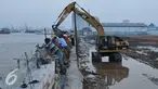 Alat berat dikerahkan untuk menyelesaikan proyek pembangunan tanggul di Pantai Muara Baru, Jakarta, Rabu (2/12). Proyek tanggul tersebut bertujuan untuk menahan banjir rob yang sering melanda kawasan Muara Baru. (Liputan6.com/Gempur M Surya)