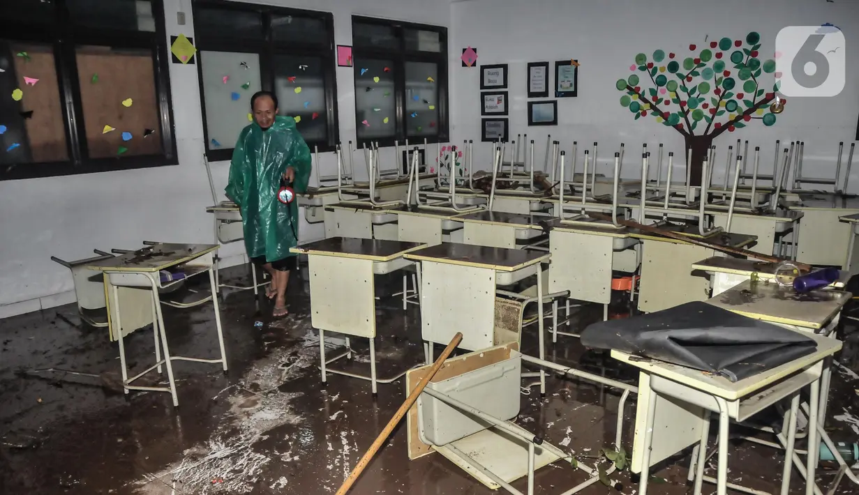 Petugas saat memeriksa kondisi ruang kelas pasca terjangan banjir di Madrasah Tsanawiyah (MTs) Negeri 19 di Jalan Pinang Kalijati, Pondok Labu, Cilandak, Jakarta Selatan, Kamis (6/10/2022). Peristiwa robohnya tembok sekolah bersamaan dengan hujan deras pada sore tadi tersebut diakibatkan oleh terjangan banjir yang menyebabkan tiga siswa tewas dan dua lainnya luka-luka. (merdeka.com/Iqbal S. Nugroho)