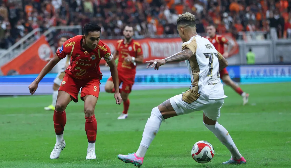 Di awal babak kedua, gelandang tengah Dewa United Banten FC, Alexis Nahuel Messidoro mampu membobol gawang Persija Jakarta yang dikawal oleh Carlos Eduardo di menit ke-55. Tampak dalam foto, bek tengah Persija, Rizky Ridho Ramadhani (kiri) berusaha menahan laju penyerang kiri Dewa United Banten FC, Noah Wail Sadaoui saat pertandingan lanjutan BRI Super League 2025/2026 di Jakarta International Stadium (JIS), Minggu (15/3/2026) malam WIB. (Bola.com/M Iqbal Ichsan)