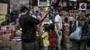 Anak-anak dan orang tua mereka melihat kembang api yang dijual di Pasar Asemka, Jakarta, Selasa (28/12/2021). Sejumlah pedagang petasan dan kembang api mulai ramai di Asemka meskipun Pemprov DKI dan Polda Metro Jaya melarang penjualan serta perayaan malam Tahun Baru. (merdeka.com/Iqbal S Nugroho)