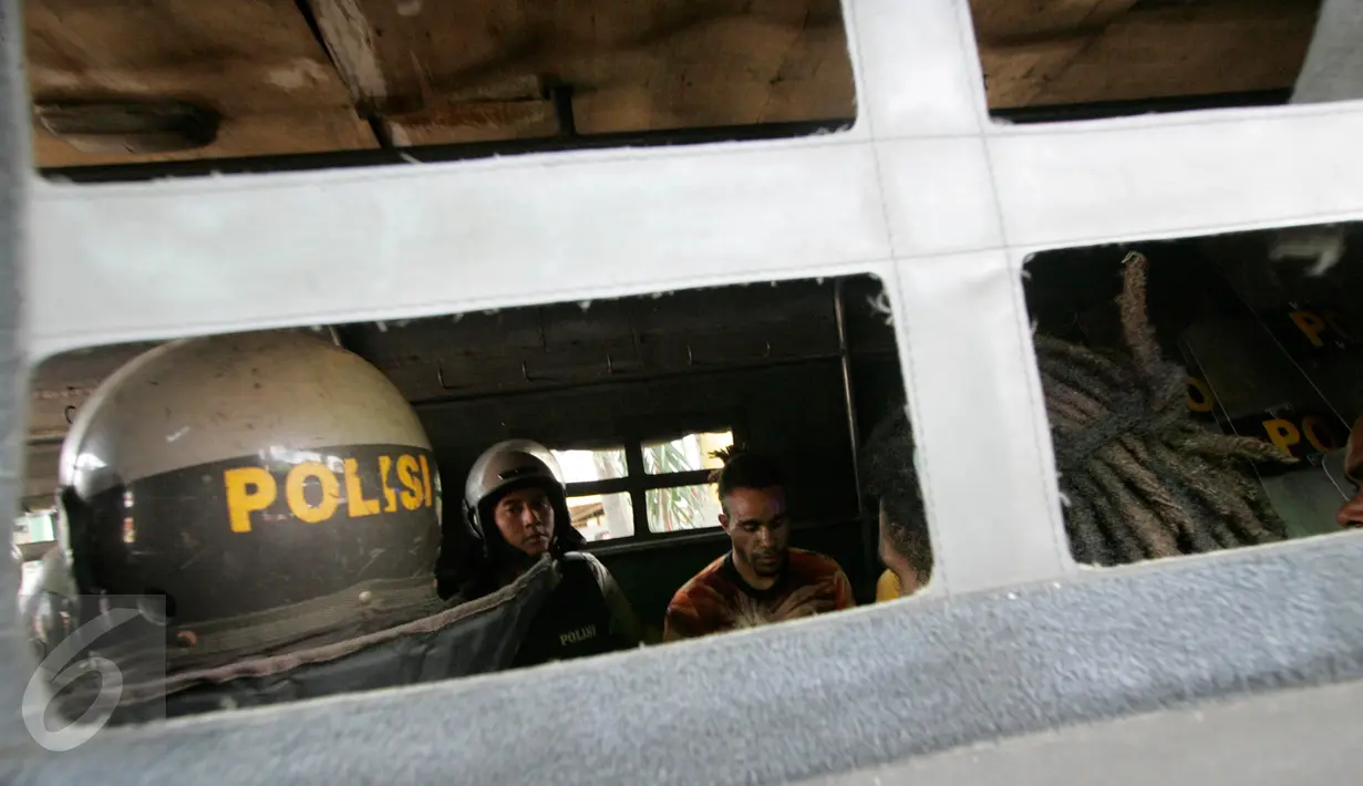 Sejumlah warga Papua dibekuk petugas kepolisian saat melakukan demonstrasi di depan Asrama Mahasiswa Papua di Yogyakarta, Jumat (15/7). Mereka menggelar aksi menuntut kemerdekaan Papua. (Liputan6.com/Boy Harjanto)