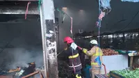 Petugas pemadam kebakaran memadamkan api yang melalap sejumlah lapak pedagang di Pasar Sentiong, Balaraja, Kabupaten Tangerang. (Liputan6.com/Pramita Tristiawati)