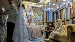 Pekerja melayani pembeli bahan kain di Pasar Tanah Abang, Jakarta, Kamis (1/4/2021). Kemenperin ingin meningkatkan daya saing industri Tekstil dan Produk Tekstil (TPT) nasional, salah satunya dengan berupaya mengurangi ketergantungan terhadap bahan baku tekstil impor. (Liputan6.com/Johan Tallo)