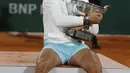 Petenis Rafael Nadal memegang trofi saat merayakan kemenangannya atas Novak Djokovic pada final Prancis Terbuka 2020 di Stadion Roland Garros, Paris, Prancis, Minggu (11/10/2020). Dengan kemenangan ini, Nadal menyamai rekor Roger Federer dengan meraih 20 gelar Grand Slam. (AP Photo/Michel Euler)