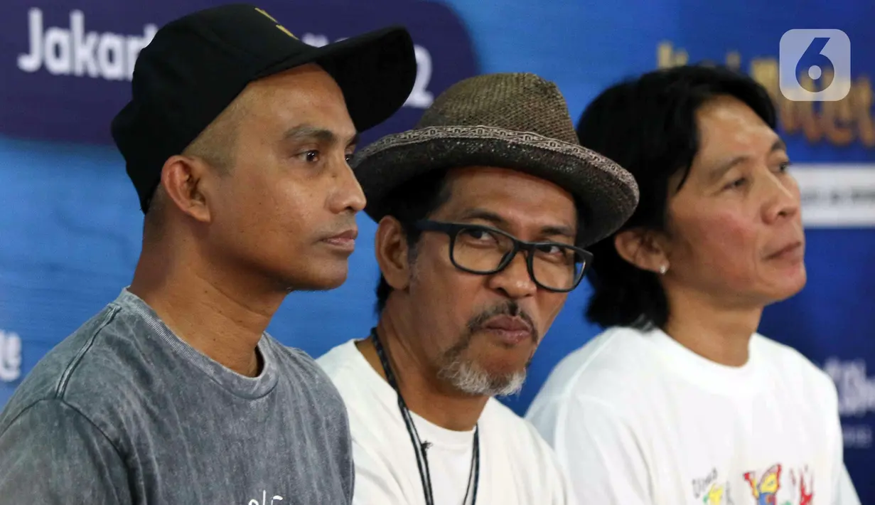 Personel grup band Slank Ridho (tengah) bersama bassist Ivan dan drummer Bimbim saat peluncuran Slankops di Basecamp Slank, Jakarta, Selasa (19/7/2022). Slankops diluncurkan sebagai bentuk kepedulian dan dedikasi personelnya untuk memberdayakan generasi muda yang utamanya para Slanker dan wadah berproses menjadi wirausaha mandiri serta tangguh. (Liputan6.com/Herman Zakharia)
