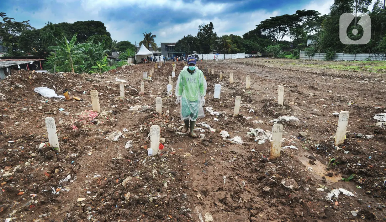 Seorang petugas berjalan di antara makam jenazah dengan protokol COVID-19 di TPU Srengseng Sawah 2, Jakarta, Selasa (9/2/2021). TPU Srengseng Sawah 2 yang sudah lebih dari sepekan dibuka untuk pemakaman dengan protokol COVID-19 ini mampu menampung seribu lebih liang lahat. (merdeka.com/Arie Basuki)