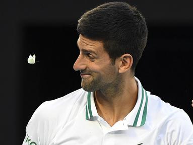 Seekor kupu-kupu berusaha menghampiri Novak Djokovic yang sedang melakukan pertandingan melawan Aslan Karatsev. (Foto: AFP/William West)