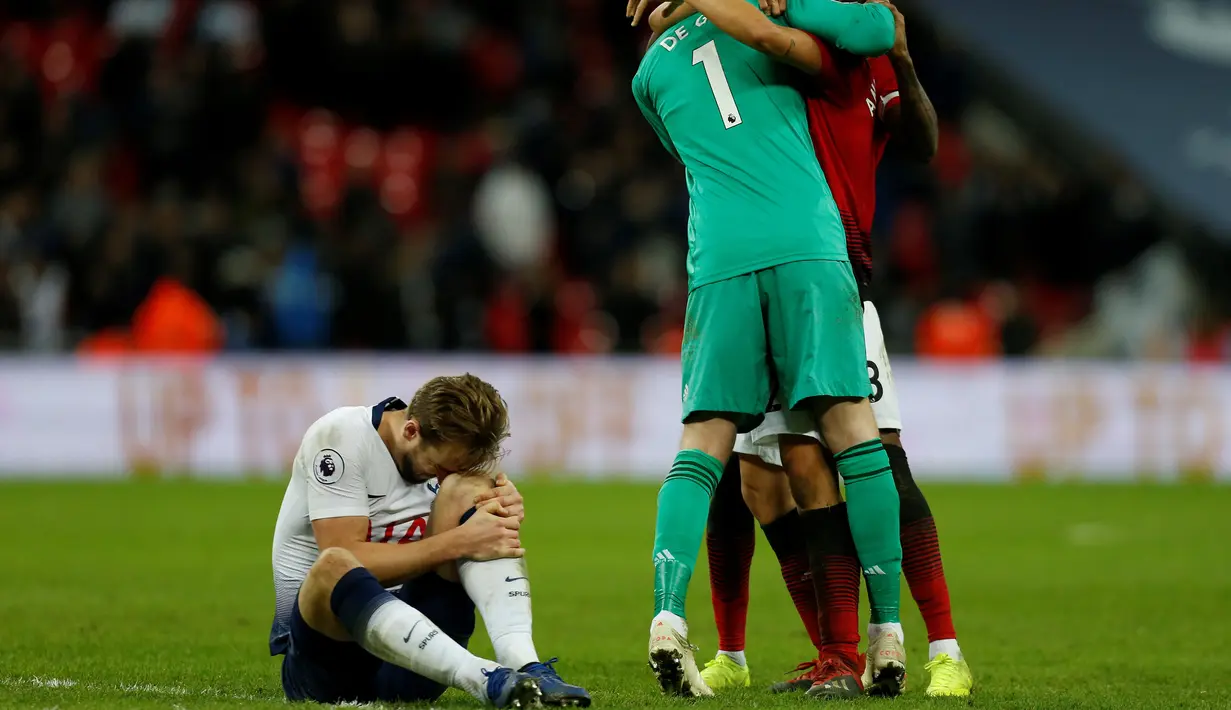 Ekspresi berbeda diantara kedua kubu pada laga lanjutan Premier League yang berlangsung di stadion Wembley, Inggris, Minggu (13/1). Man United menang atas Tottenham Hotspur 1-0. (AFP/Adrian Dennis)