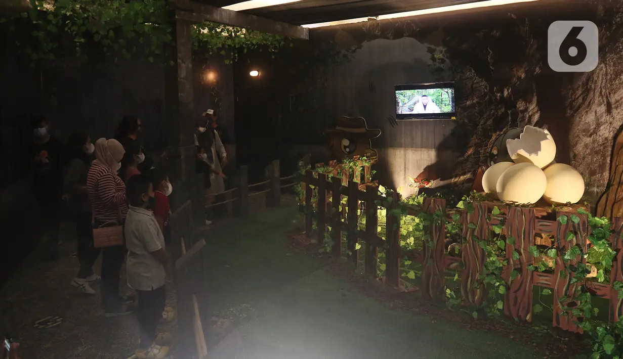 Pengunjung menyaksikan replika hewan prasejarah dalam wahana Dino Factory by Dino Island di Mal Kota Kasablanka, Jakarta, Jumat (17/12/2021). Wahana juga menjadi sarana edukasi pengetahuan tentang hewan-hewan prasejarah kepada para pengunjung. (Liputan6.com/Herman Zakharia)