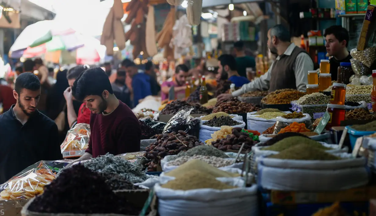 Warga Palestina berbelanja untuk persiapan menjelang bulan suci Ramadan di pasar al-Zawiya di Kota Gaza pada 20 April 2020. Tahun ini, miliaran umat Muslim di dunia bersiap memasuki bulan suci Ramadan di tengah situasi pandemi Covid-19. (MAHMUD HAMS / AFP)