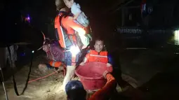 Penyelamat mengevakuasi orang-orang dari daerah banjir di Kota Ozamiz, Misamis Occidental, Filipina (25/12/2022). Dua orang tewas dan hampir 46.000 lainnya meninggalkan rumah mereka saat banjir pada libur Hari Natal. (Handout / Philippine Coast Guard (PCG) / AFP)
