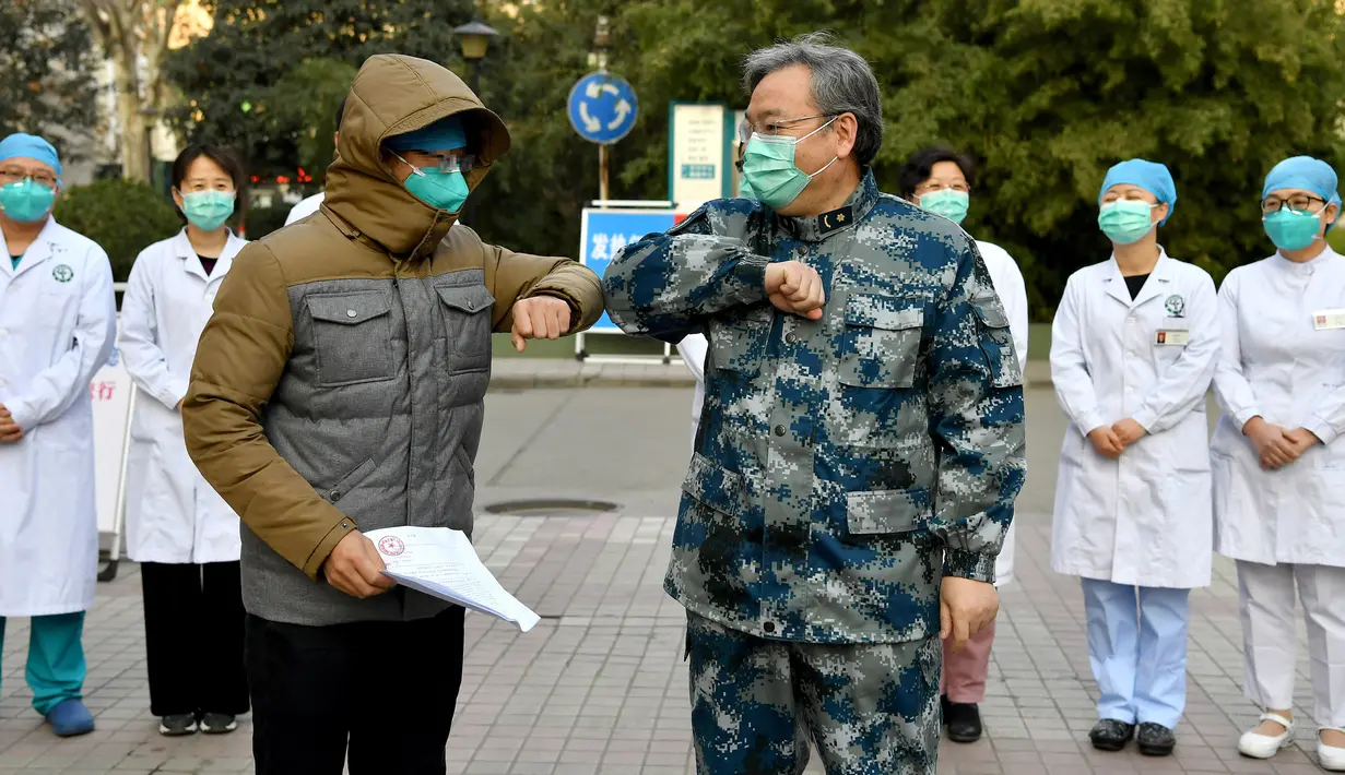 Pasien yang dinyatakan sembuh dari virus corona beradu siku dengan petugas medis di Rumah Sakit Tangdu Universitas Kedokteran Militer Angkatan Udara Xi'an, Provinsi Shaanxi, China, Selasa (4/2/2020). Ini adalah pasien pertama yang dinyatakan sembuh dari virus corona di Shaanxi. (Xinhua/Liu Xiao)