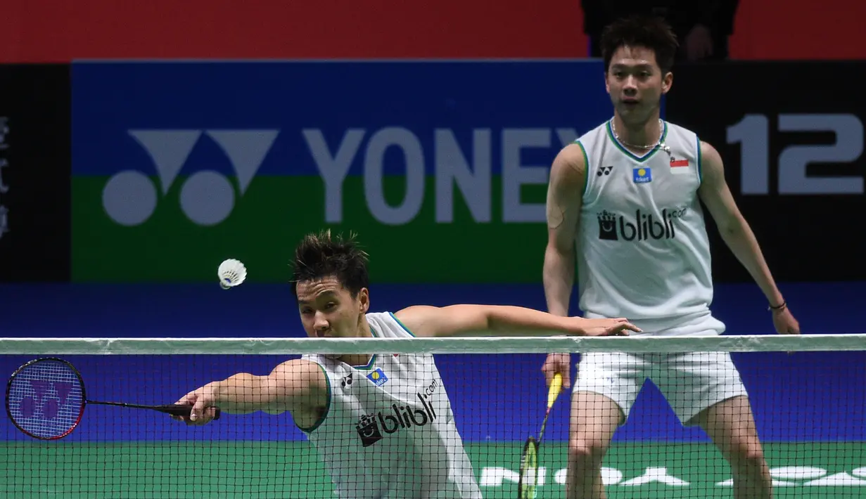 Pasangan Indonesia Kevin Sanjaya Sukamuljo/Marcus Fernaldi Gideon mengembalikan kok kepada pasangan Jepang Hiroyuki Endo/Yuta Watanabe pada laga final ganda putra All England 2020 di Birmingham, Inggris, Minggu (15/3/2020). Kevin/Marcus kalah dengan skor 18-21, 21-12, dan 19-21. (Oli SCARFF/AFP)