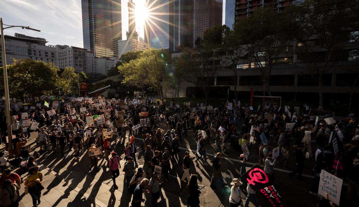 Para pengunjuk rasa membanjiri jalan-jalan di beberapa kota besar AS pada hari Sabtu untuk menentang kebijakan-kebijakan Presiden Donald Trump. (ETIENNE LAURENT/AFP)