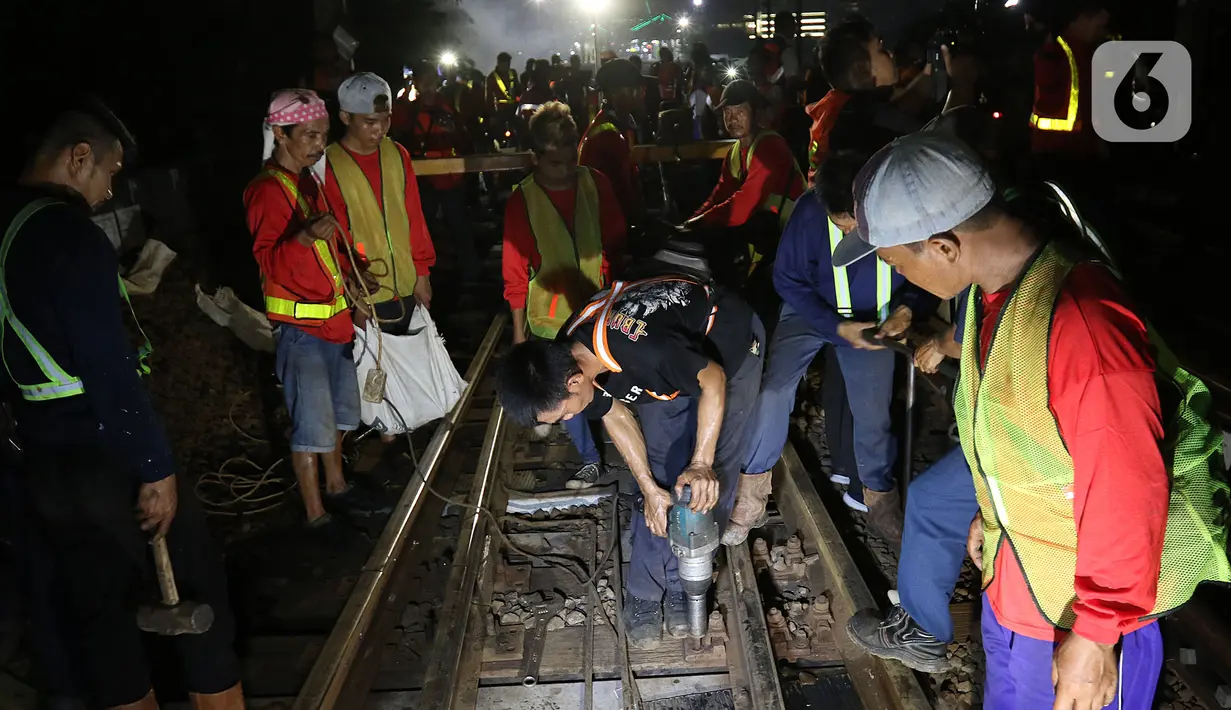 Sejumlah petugas merevitalisasi wesel rel di Stasiun KA Gambir, Jakarta, Kamis (14/2/2020) malam. PT KCI dan PT KAI Daop 1 Jakarta mengganti wesel rel di Stasiun Gambir dan Stasiun Jakarta Kota secara paralel yang akan berlangsung pada 13-23 Februari 2020. (Liputan6.com/Herman Zakharia)