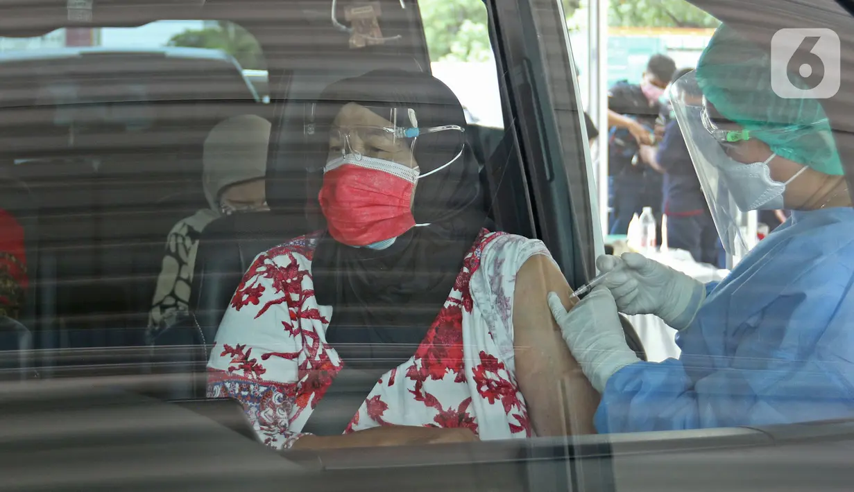 Warga lanjut usia (lansia) mendapatkan vaksinasi Covid-19 secara drive-thru di area parkir Hall C JIExpo Kemayoran, Jakarta, Rabu (3/3/2021). Kementerian Kesehatan berkolaborasi bersama sejumlah mitra dalam layanan vaksinasi drive thru tersebut. (Liputan6.com/Herman Zakharia)