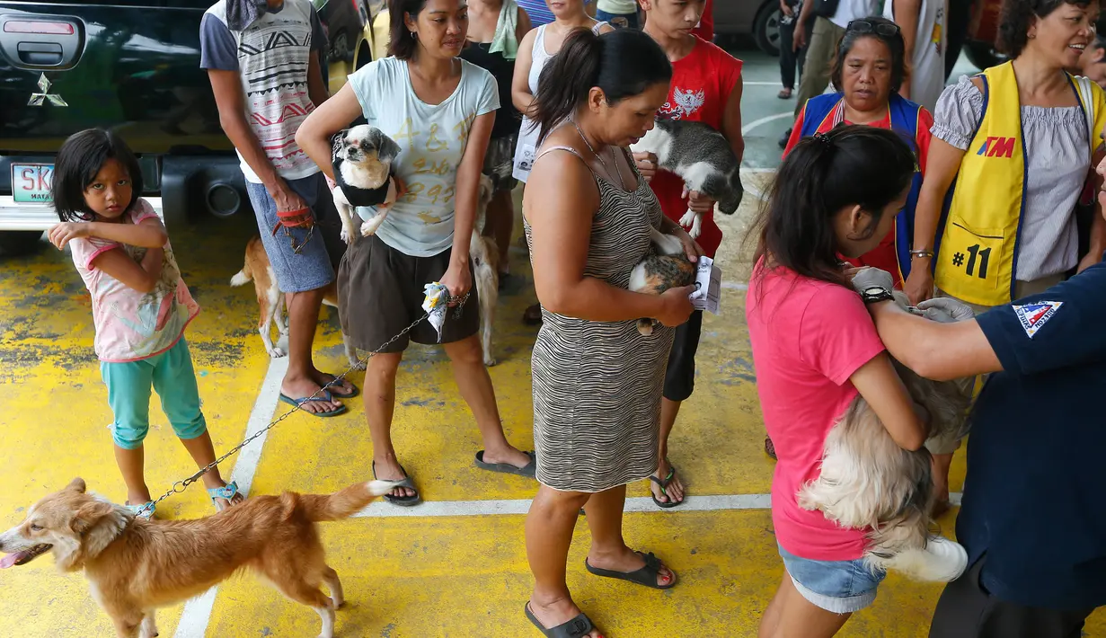 Para warga membawa hewan piaraannya untuk diberi vaksin anti rabies di Payatas, Manila, Filipina, Selasa (26/9). Menjelang Hari Rabies Sedunia, HSI pelopori kampanye anti-rabies untuk mencapai berantas infeksi rabies pada 2020. (AP Photo/Bullit Marquez)