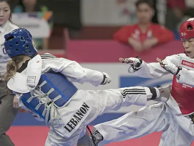 Atlet taekwondo Indonesia, Mariska Halinda, saat melawan wakil Lebanon, Laetitia Aoun, pada babak perdelapan final Asian Games di JCC, Jakarta, Senin (20/8/2018). Mariska Halinda kalah poin 22-23 dari Laetitia Aoun. (Bola.com/Peksi Cahyo)