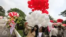 Ekspresi warga yang berfoto dengan latar belakang balon berwarna merah putih yang menghiasi halaman Balai Kota, Jakarta, Senin (8/5). Ribuan balon yang berwarna merah putih ini meramaikan kemeriahan di Balai Kota. (Liputan6.com/Faizal Fanani)