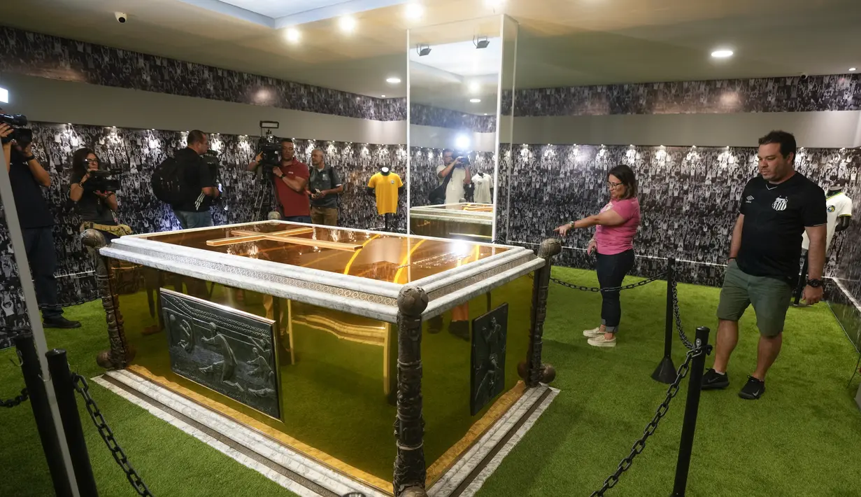 Para penggemar berdiri di samping makam mendiang legenda sepak bola Brasil Pele yang dibuka untuk umum untuk pertama kalinya, di mausoleum Necropole Ecumenica Memorial Cemetery di Santos, Senin (15/5/2023). (AP Photo/Andre Penner)