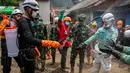 Upaya pencarian juga dibantu anjing pelacak untuk mencari posisi korban. Tampak dalam foto, petugas penyelamat disemprot disinfektan setelah membawa korban dalam operasi pencarian di lokasi longsor di Desa Situkung, Banjarnegara, Jawa Tengah, pada 20 November 2025. (DEVI RAHMAN/AFP)