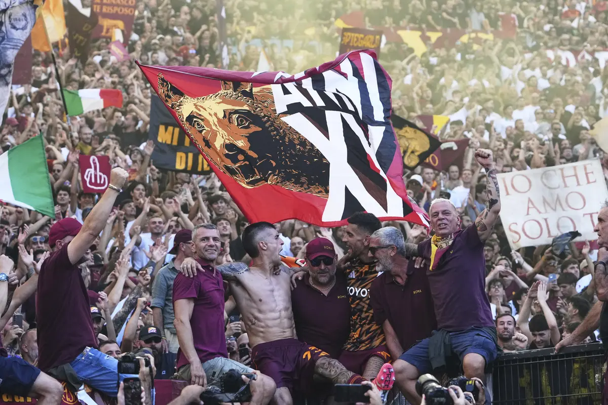 Pemain AS Roma, Gianluca Mancini (tengah kiri) dan Lorenzo Pellegrini (tengah kanan), merayakan kemenangan bersama para suporter