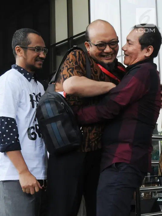Penyidik senior KPK Novel Baswedan (tengah) berpelukan dengan Wakil Ketua KPK Saut Situmorang di Gedung KPK, Jakarta, Jumat (27/7). Sebelumnya Novel Baswedan absen 16 bulan untuk menyembuhkan matanya yang diserang air keras. (Merdeka.com/Dwi Narwoko)