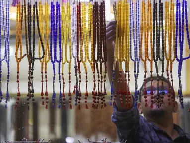 Seorang pedagang memajang tasbih di sebuah pasar di Kota Kuwait, selama bulan suci Ramadhan, pada 26 Maret 2023. (AFP/YASSER AL-ZAYYAT)
