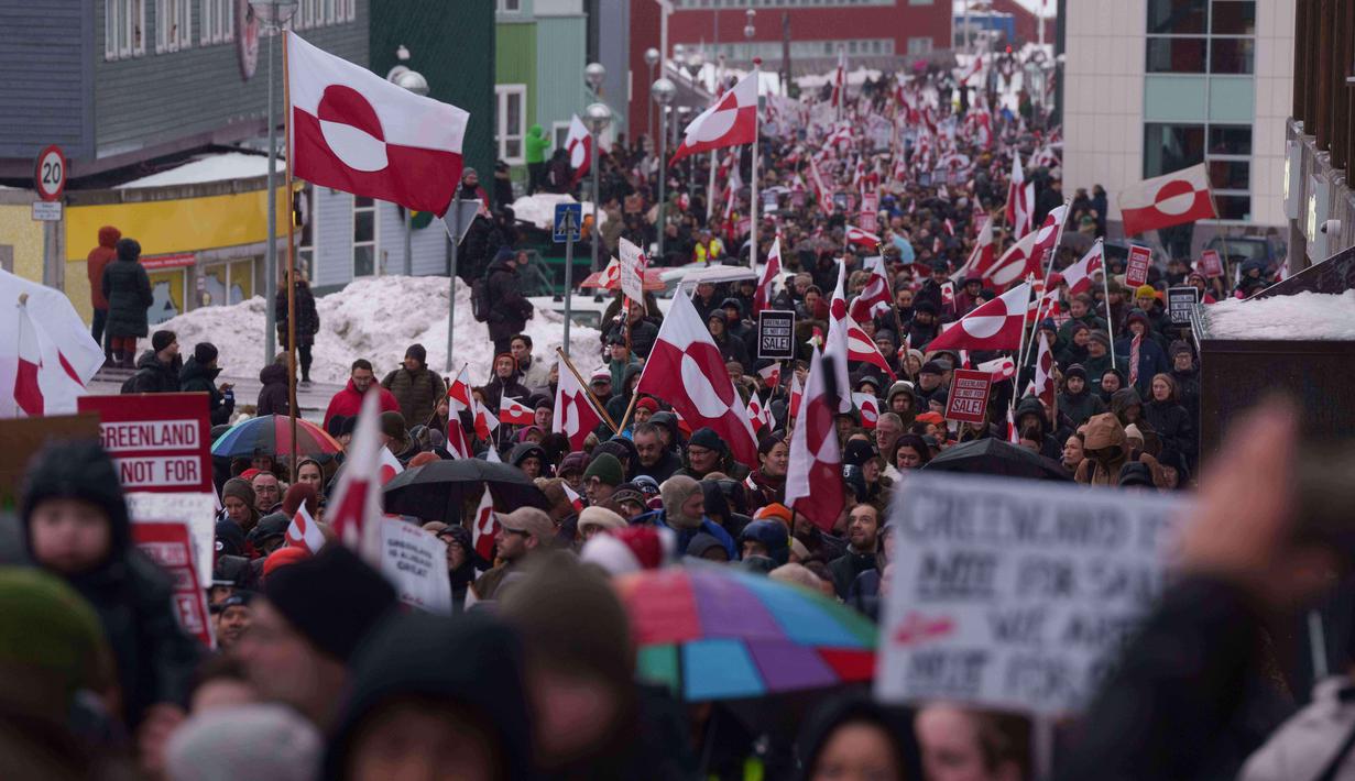 Sebagai informasi, Greenland dikenal memiliki cadangan mineral strategis, termasuk unsur tanah jarang (rare earth), yang menjadi rebutan di tengah transisi energi global dan persaingan teknologi. Tampak dalam foto, sekelompok orang berjalan menuju konsulat AS untuk memprotes kebijakan Presiden Amerika Serikat (AS), Donald Trump, terhadap Greenland di depan konsulat AS di Nuuk, Sabtu 17 Januari 2026. (AP Photo/Evgeniy Maloletka)